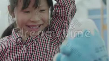 可爱的亚洲小女孩在家和妈妈玩。 一个<strong>兴奋</strong>的女孩玩一个接一个的玩具玩得<strong>开心</strong>